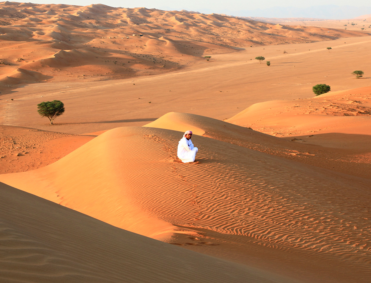 Bédouin dans le désert de Wahiba au coucher du soleil, voyage en liberté à Oman avec Nirvatravel