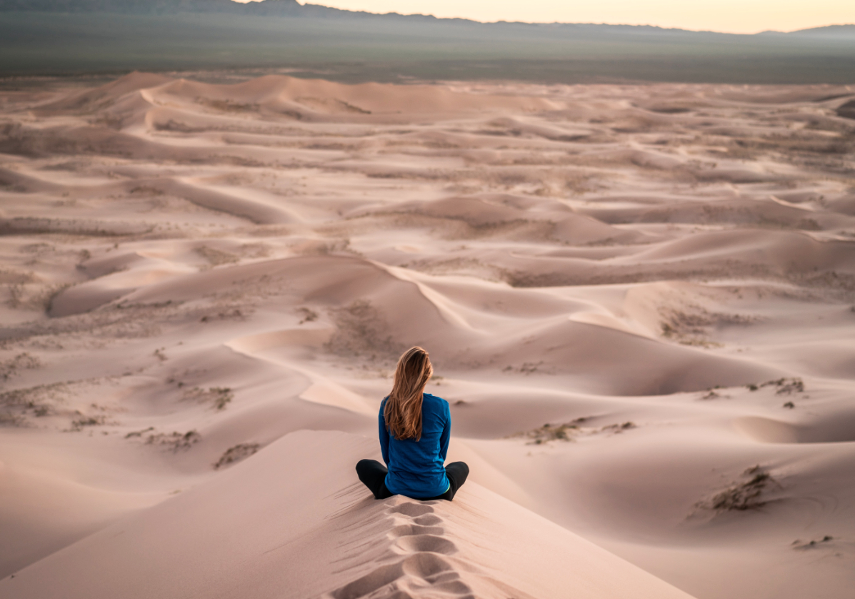 Femme méditant dans les dunes du désert de Gobi, voyage en Mongolie avec Nirvatravel