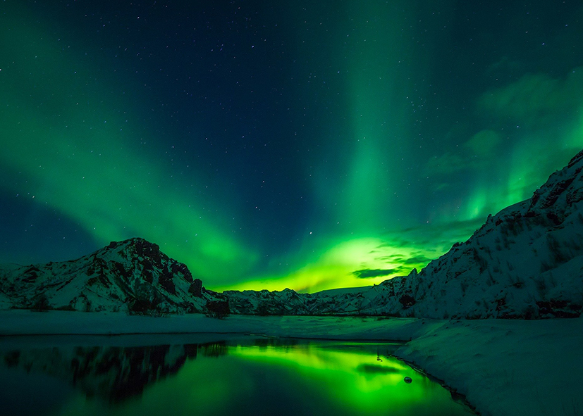 Aurore boréale sur les montagnes islandaises, voyage hors des sentiers battus en Islande avec Nirvatravel