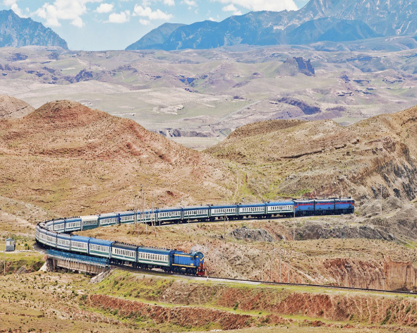 Train ouzbek traversant les paysages de montagnes en Ouzbékistan avec une agnece Nirvatravel